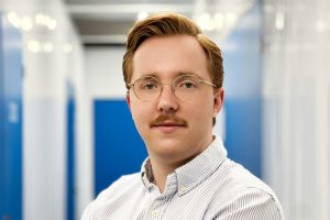 Frontalansicht auf den Inhaber von MaximalDental. Junger Mann in Flur.