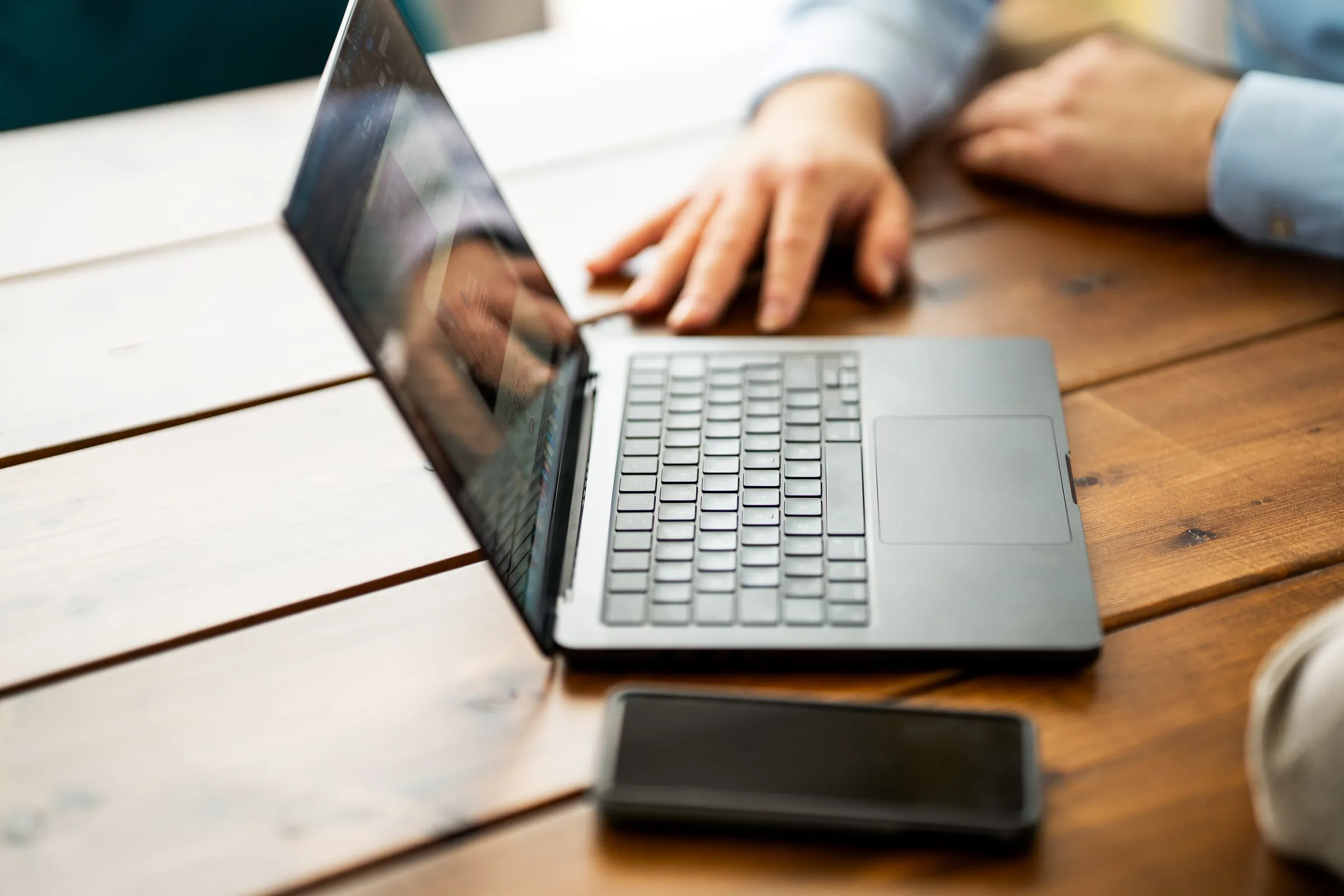 Laptop und Smartphone auf einem Holztisch