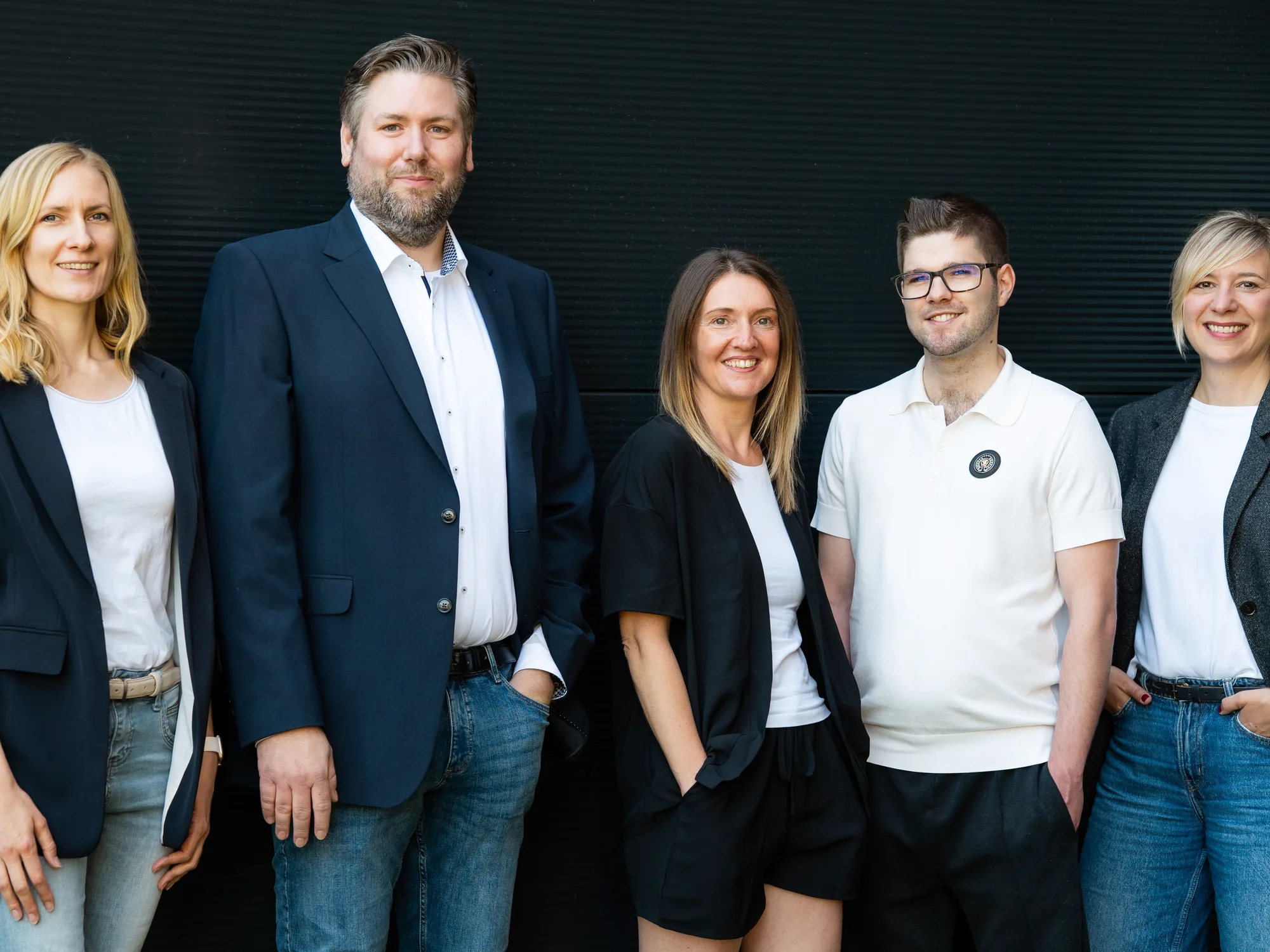 Das Team von Finke Praxismarketing vor einer dunklen Wand