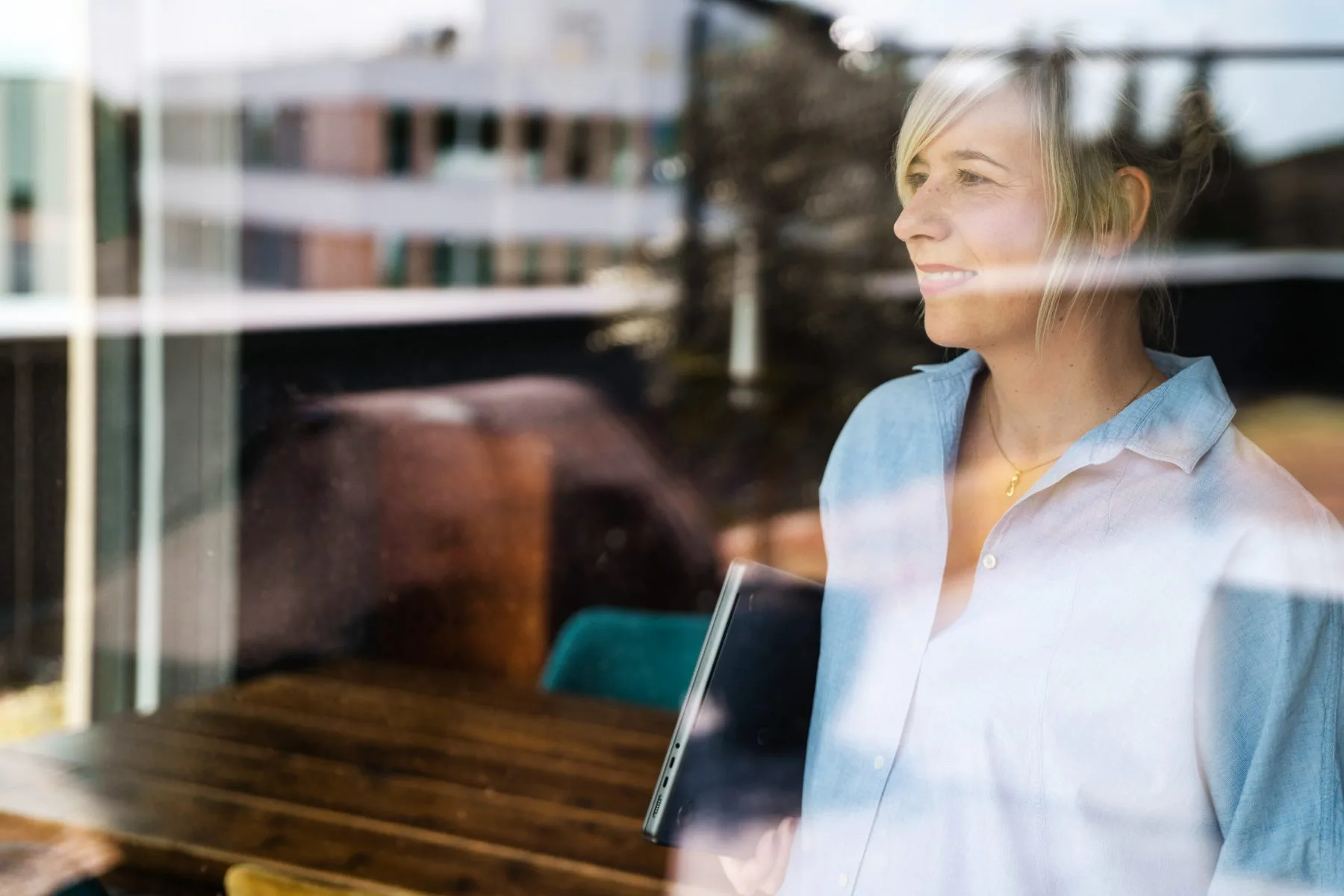 Mitarbeiterin von Finke Praxismarketing, durch eine Fensterscheibe fotografiert